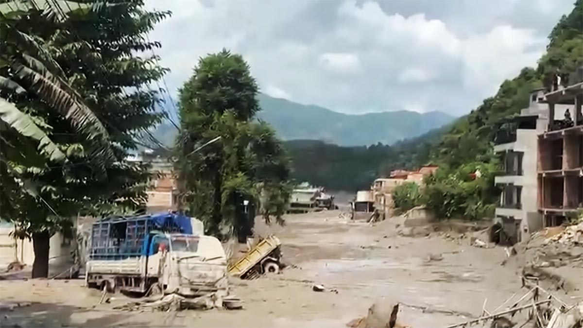 Buildings and vehicles damaged by flash flooding in northern Nepal on August 26, 2026