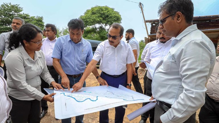 Minister Bimal Rathnayake inspects the Kolonnawa flood-control project plan with officials during a field visit