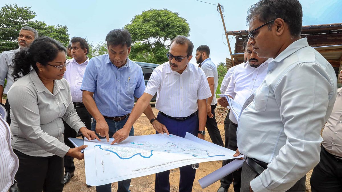 Minister Bimal Rathnayake inspects the Kolonnawa flood-control project plan with officials during a field visit