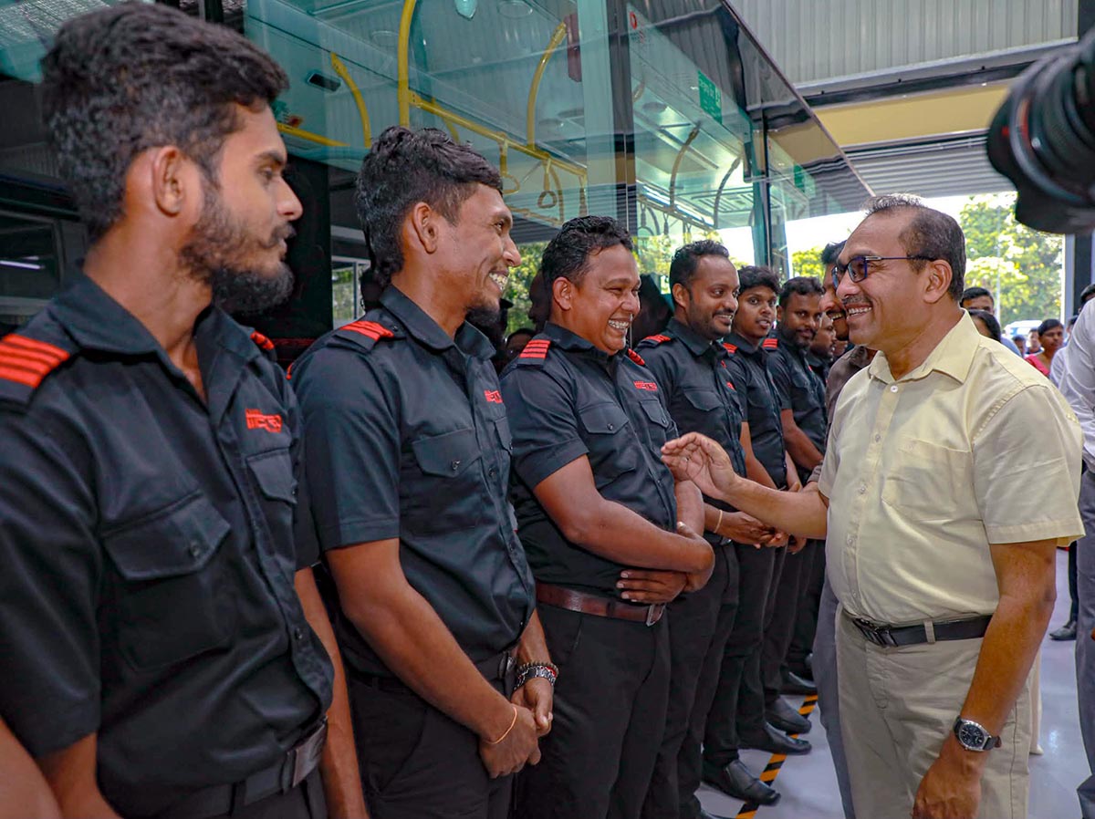 Minister Bimal Rathnayake smiling during a conversation with workers at the Kadawatha Metro Depot
