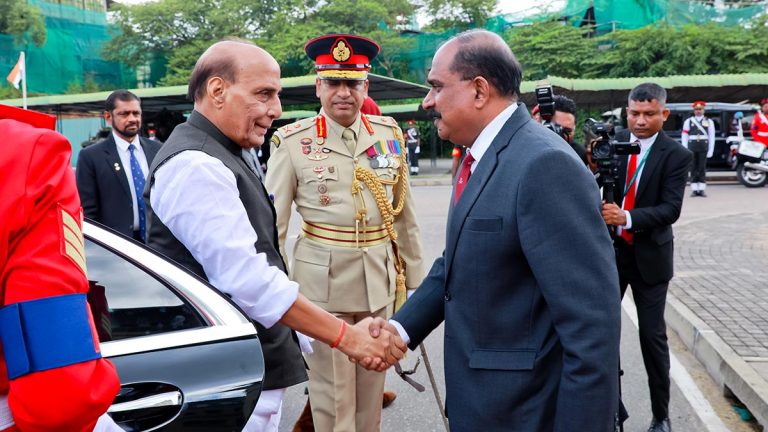 Indian Defence Minister Rajnath Singh shakes hands with Deputy Defence Minister Major General Aruna Jayasekara after arriving at the Defence Headquarters Complex in Kotte