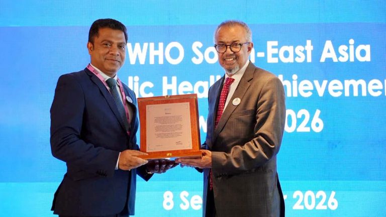 Sri Lanka Health Minister Dr. Nalinda Jayatissa receiving WHO recognition from WHO Director-General Dr. Tedros Adhanom Ghebreyesus