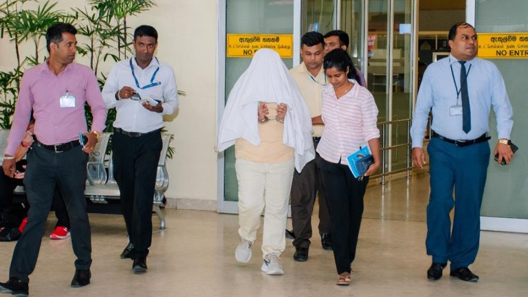 Anusha Lakmali, alias ‘Achini’, escorted by police at Bandaranaike International Airport in Katunayake, Sri Lanka