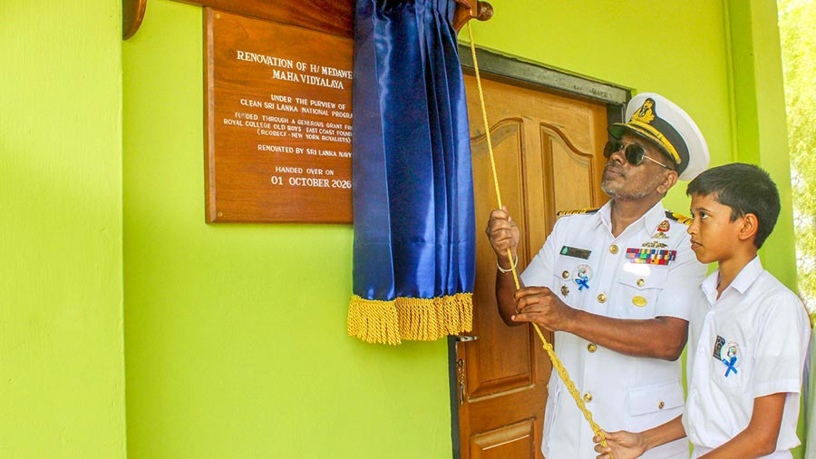 Sri Lanka Navy Captain Senaka Premaratne and a student unveil a commemorative plaque at Medawelana Maha Vidyalaya in Tissamaharama