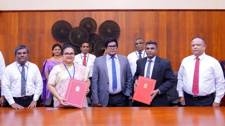 Officials pose with signed MoU folders after the Inland Revenue and Excise Departments sign an agreement in Sri Lanka